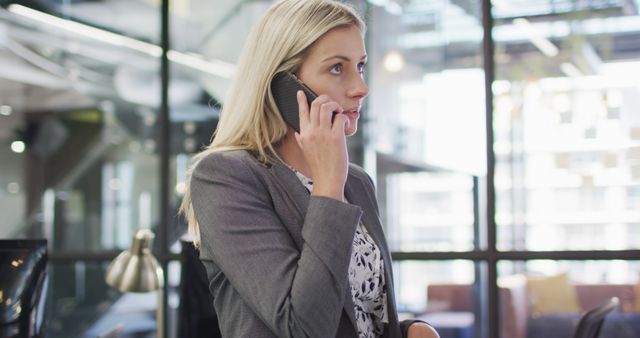 Focused Businesswoman Engaged in Phone Conversation in Modern Office - Download Free Stock Images Pikwizard.com