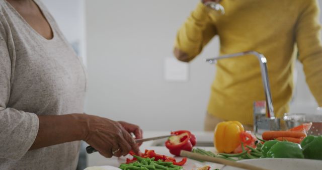 Elderly Woman Preparing Vegetables for Healthy Meal while Drinking Smoothie - Download Free Stock Images Pikwizard.com