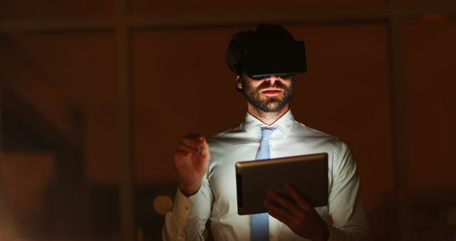 Man Using Virtual Reality Headset in Dark Office with Tablet - Download Free Stock Images Pikwizard.com