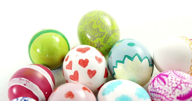 A collection of colorful, decorated Easter eggs is displayed against a white background, with copy space. These eggs, often associated with Easter traditions, showcase a variety of patterns and designs.