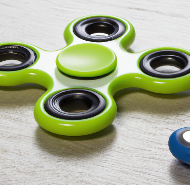 Image of close up of green fidget spinner on grey background. Playing object and toy concept.