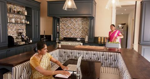 Indian Woman in Sari Working on Laptop in Kitchen