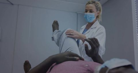 Masked Healthcare Professional Assisting Patient in Clinical Setting