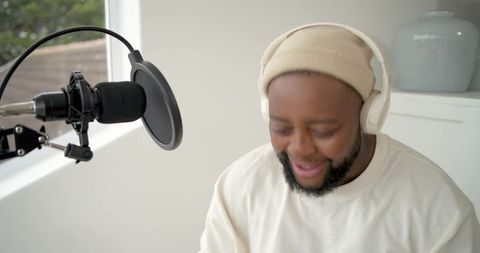 Recording podcast in minimal home studio with boom microphone and headphones, daylight