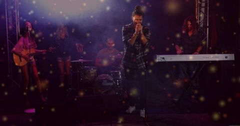 Indie band performing live on smoky club stage with emotive lead singer gripping microphone