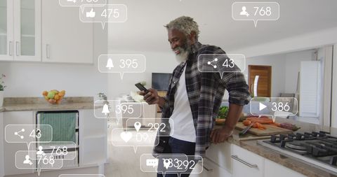 Engaged Senior Man Checking Smartphone in Modern Kitchen