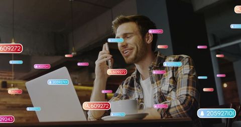 Man working remotely in cafe with laptop and smartphone showing ar notification overlays