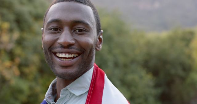 Smiling Man Wrapped in Red, White, and Blue Blanket Outdoors - Download Free Stock Images Pikwizard.com