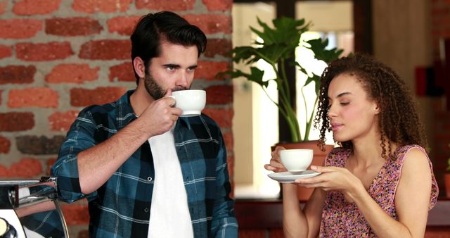 Young friends drinking coffee in trendy cafe with brick wall background - Download Free Stock Images Pikwizard.com