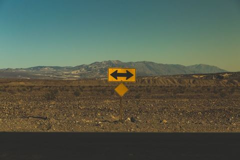 Directional road sign in arid desert landscape