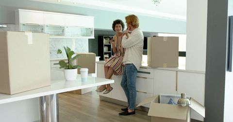 Couple Relaxing Amid Move, Unpacking in New Kitchen