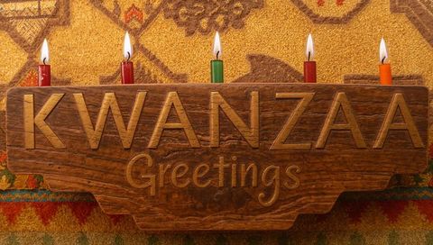 Kwanzaa greetings carved wood plaque featuring five lit candles, warm woven rug background