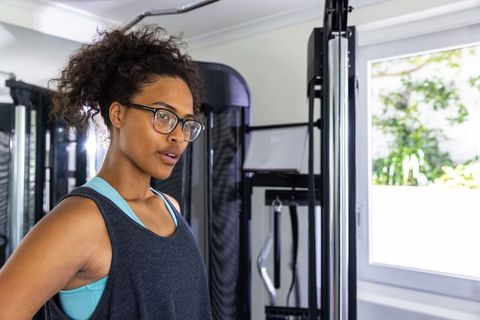 Determined woman in activewear standing confidently in gym