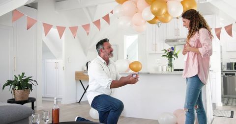 Man Proposing Love with Engagement Ring in Joyful Home Celebration