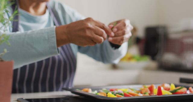 Chef adding final touches to a tray of vibrant vegetables in a contemporary kitchen setting, highlighting healthy food preparation. Suitable for use in articles about healthy eating, lifestyle blogs, cooking magazines, and culinary websites.