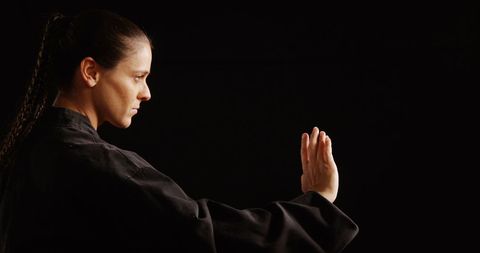 Confident Karate Athlete Striking Intense Pose in Studio