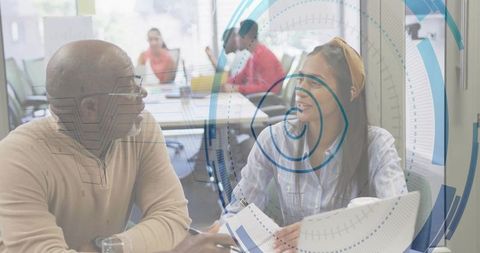 Senior Mentor and Mentee Collaborating in Modern Office