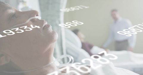 Close-up male patient receiving oxygen via nasal cannula with floating telemetry numbers