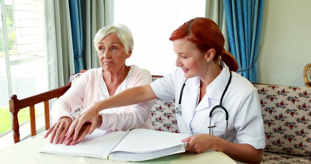 Senior Woman Receiving Assistance from Home Care Nurse with Medical Book - Download Free Stock Images Pikwizard.com