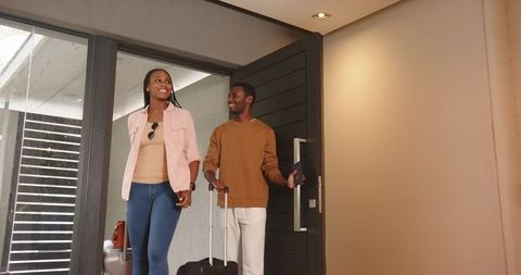 Happy Couple Entering Hotel Foyer with Luggage