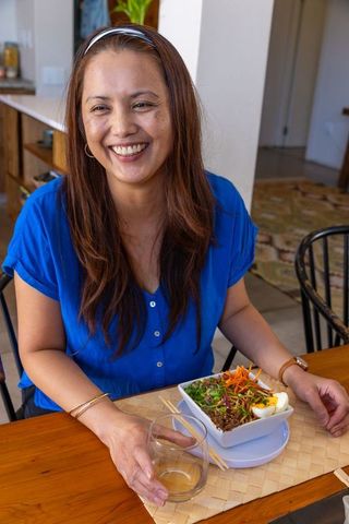 Smiling woman enjoying healthy salad at home
