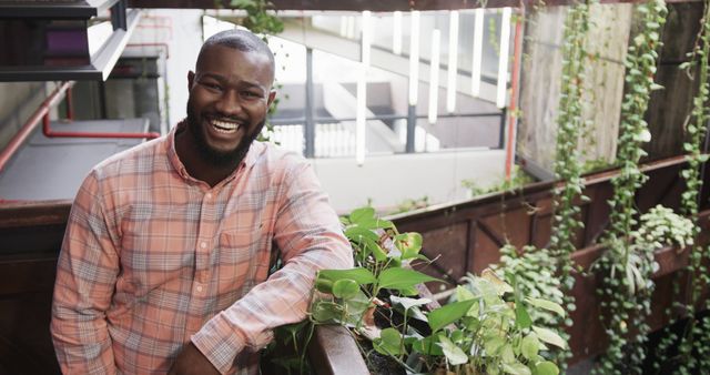 Smiling Man Standing in Bright Indoor Garden Setting - Download Free Stock Images Pikwizard.com