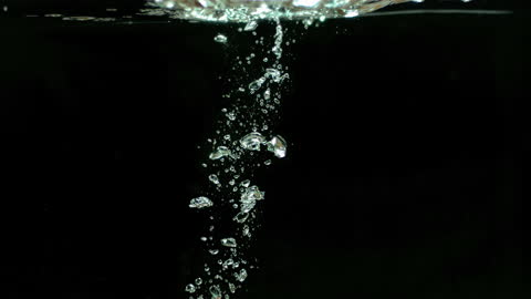 Tomato Plunging into Water Creating Splashes and Bubbles