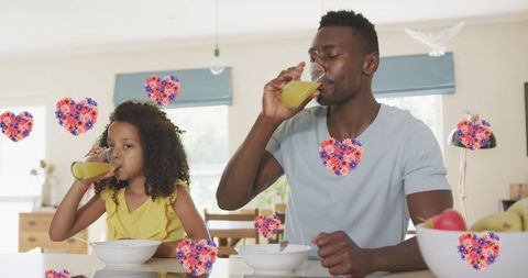 Father and Daughter Enjoying Juice at Kitchen Table with Decorative Hearts