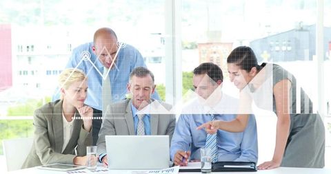 Executive Team Analyzing Financial Charts Around Laptop in Sunlit Modern Office