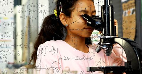 Young schoolgirl exploring science with microscope