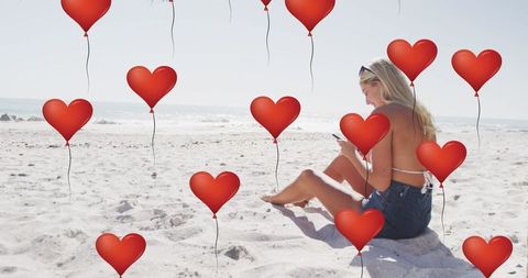 Woman Engaging with Social Media on Sunny Beach with Heart Icons