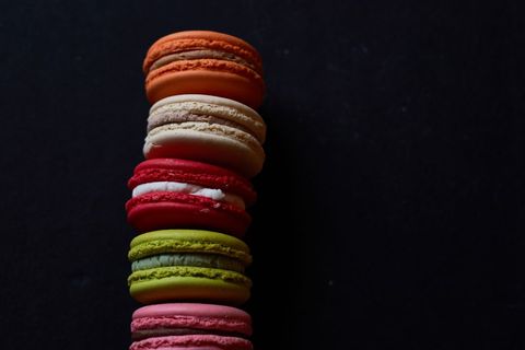 Vibrant Macarons Stacked Against Dark Background