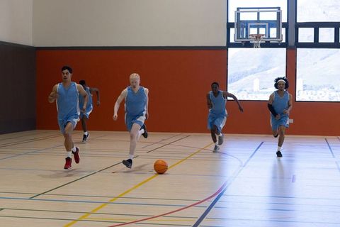Basketball team competing for ball on indoor court