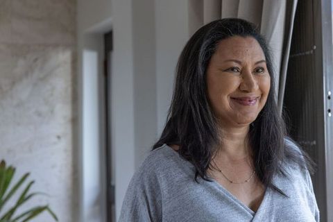 Senior Woman Contemplating by Window in Minimalist Living Room