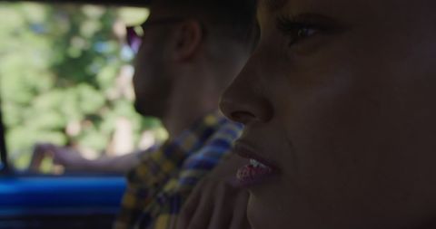 Reflective young woman journeying in car with thoughtful expression