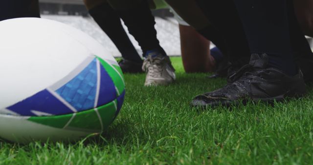 Closeup of Rugby Players' Feet in Game Huddle with Rugby Ball on Grass Field - Download Free Stock Images Pikwizard.com