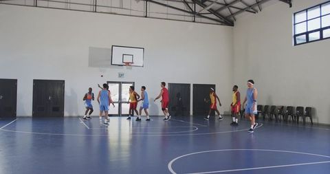 Diverse male basketball players competing in indoor game