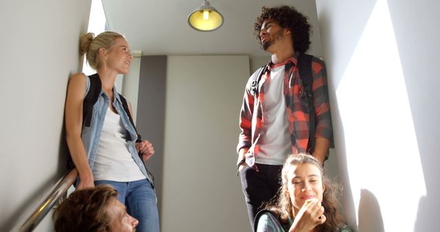 Group of young friends talking and laughing on stairs in school building - Download Free Stock Images Pikwizard.com