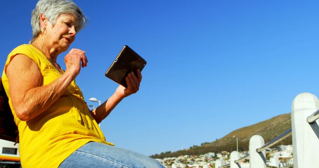 Senior Woman Enjoying Digital Tablet Outdoors on Sunny Day - Download Free Stock Images Pikwizard.com