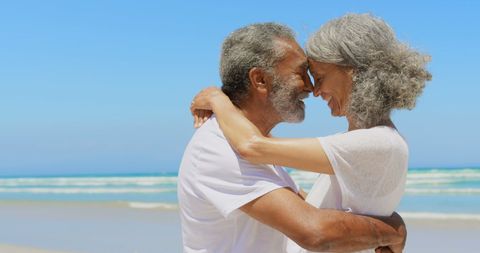 Senior Couple Embracing Joyfully on Sunny Beachfront Shoreline - Download Free Stock Images Pikwizard.com