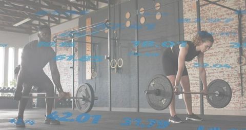 Pair performing barbell deadlifts with augmented reality metrics overlay in industrial gym