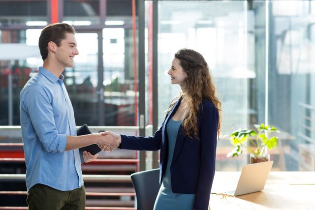 Smiling business executives interacting with each other in office