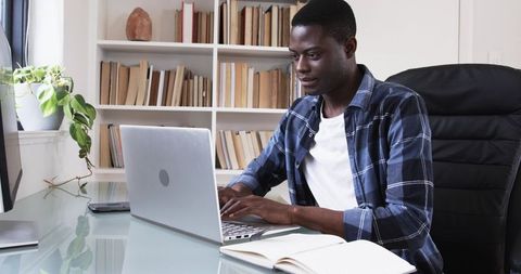 Focused professional typing on laptop in home office setup
