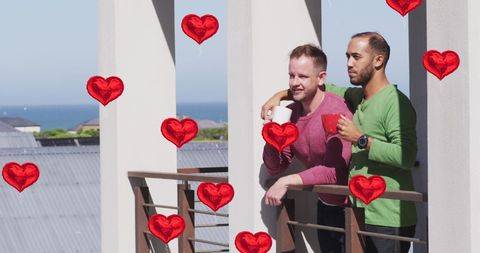 Diverse couple embracing on balcony with heart symbols
