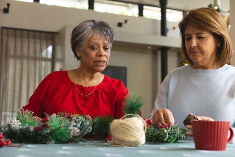 Senior women crafting festive holiday wreaths at home