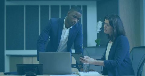 Corporate colleagues reviewing tablet during boardroom strategy meeting and collaboration