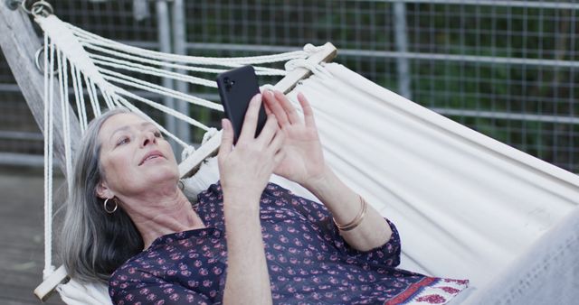 Mature Woman Relaxing in Hammock Using Smartphone Outdoors - Download Free Stock Images Pikwizard.com