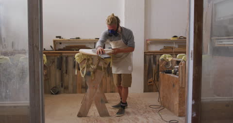 Artisan Surfboard Crafting in Coastal Workshop with Skilled Craftsman