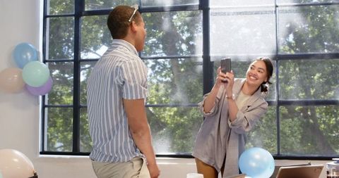 Office colleagues celebrating birthday in decorated workspace