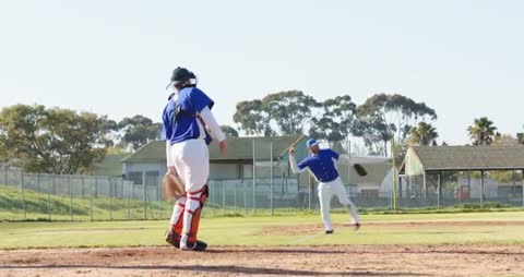 Baseball Pitcher Throwing to Catcher During Sunny Game